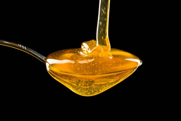 Colher de mel no fundo preto — Fotografia de Stock