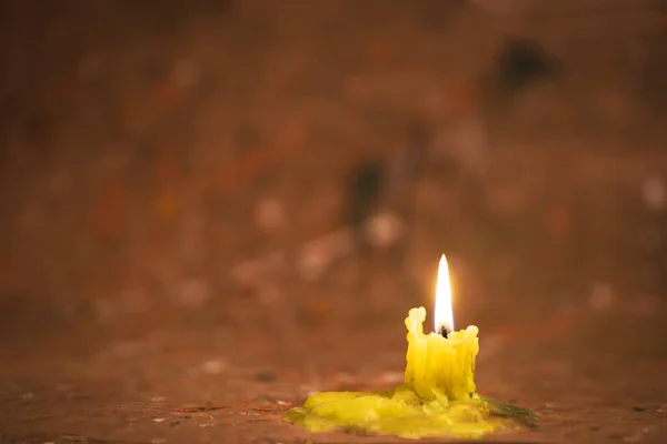 Зажженная свеча на размытом абстрактном изображении — стоковое фото