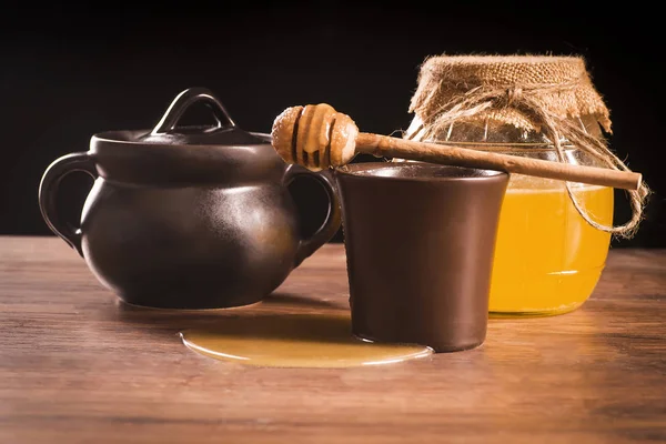 Honey concept, baked clay dishes on the background of a glass ba — Stock Photo, Image