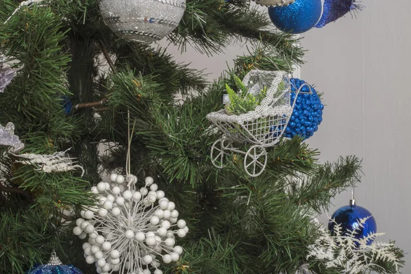 Brinquedo de Natal como uma carruagem de bebê. Brinquedo de Natal prateado na árvore de Natal — Fotografia de Stock