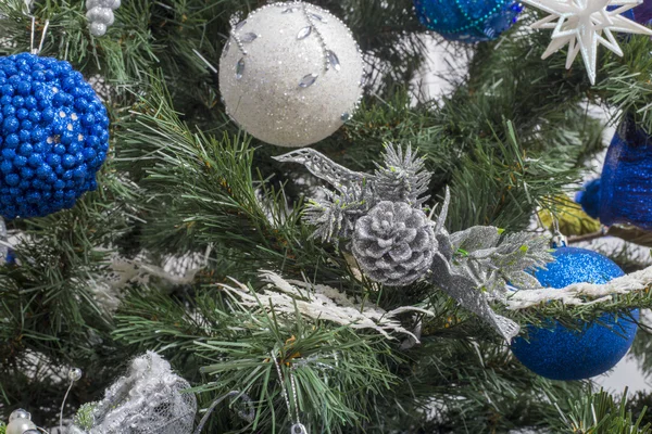 Decorações de Natal azuis e prateadas em um fundo de árvores verdes — Fotografia de Stock