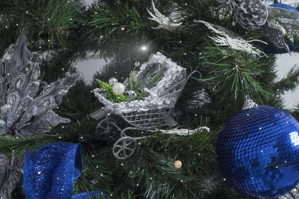 Brinquedo de Natal como uma carruagem de bebê. Brinquedo de Natal prateado na árvore de Natal — Fotografia de Stock