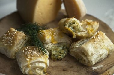 Pasta puf böreği peynir ve yeşillik ile üzerinden. Susam serpin.