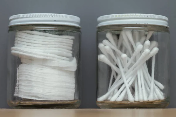 Detail of cotton buds and sponges in a glass jar on a wooden shelf — Stock Photo, Image