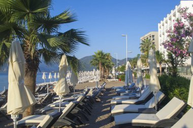 Avuç içi arasında kum üzerinde birçok plaj şemsiyeleri