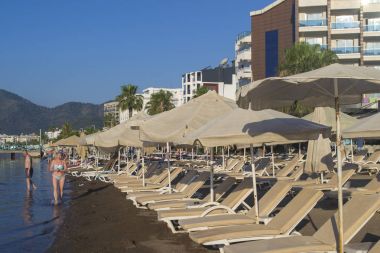 Avuç içi arasında kum üzerinde birçok plaj şemsiyeleri