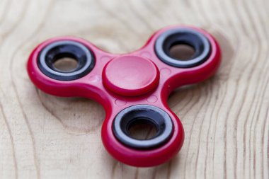 Kırmızı kıpır spinner stres giderici oyuncak ahşap arka plan üzerinde