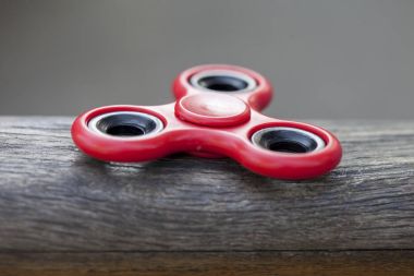 Kırmızı kıpır spinner stres giderici oyuncak ahşap arka plan üzerinde