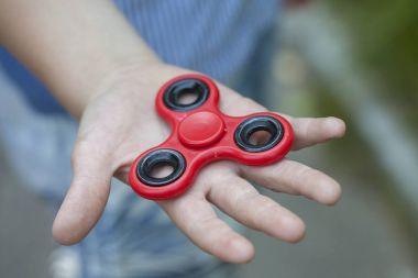Çocuk yeni bir kırmızı spinner cebinden alır.