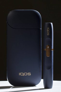 Kiev, Ukrayna - 16 Kasım 2019: siyah arka planda Iqos elektronik sigarası, Marlboro ve Philippe Morris Iqos, analog ve elektronik arasında melez sigara olarak tanımlanır.
