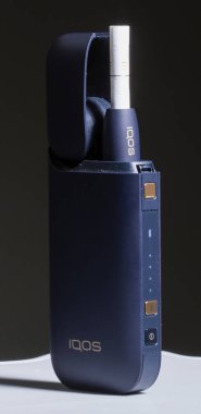 Kiev, Ukrayna - 16 Kasım 2019: siyah arka planda Iqos elektronik sigarası, Marlboro ve Philippe Morris Iqos, analog ve elektronik arasında melez sigara olarak tanımlanır.