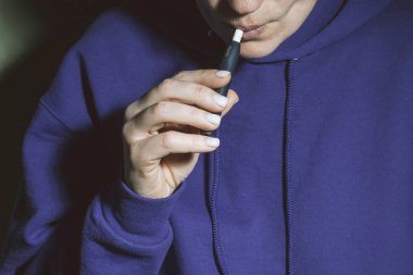 Kiev, Ukrayna - 16 Kasım 2019: Iqos tütün ısıtma sistemi eldeki kişinin arka planına karşı, Iqos tütün teknolojisi