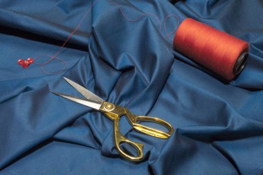 Kumaşın üzerinde altın rengi terzi makası var. Terzi.