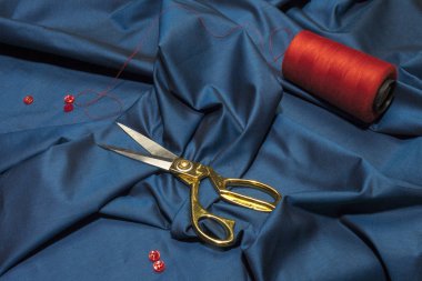 Kumaşın üzerinde altın rengi terzi makası var. Terzi.