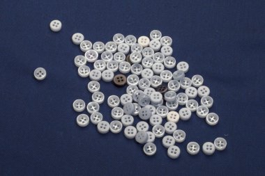 Düz görünüm dikiş araçları ile düğmeler, tekstil kumaş, iplik, düğmeler ve makas yeşil katlanmış kumaş arkaplan üzerinde yatıyordu