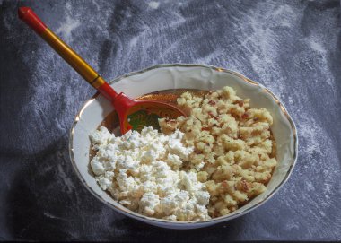Geleneksel hamur köfteleri. Köy peyniri, patates, soğan ve baharatlardan yapılmış hamur tatlısı. Kırsal bir ahşap masada, yakın plan manzaralı. Vejetaryen yemeği.