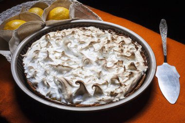 Beyaz ahşap arka planda bir fincan kahveli limonlu pasta.