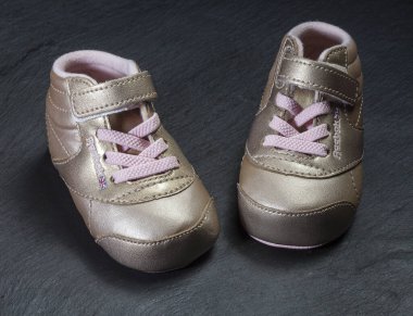 KIEV, UKRAINE - 16 Nisan 2020: Sneakers Reebok. Pembe çocuk ayakkabıları ve yeni doğan kıyafetleri. Annelik, eğitim ya da hamilelik kavramı. Tebrik kartı.
