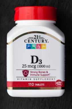 KIEV, UKRAINE - 28 Nisan 2020: D3 vitamini (cholecalciferol) ve siyah kilden bir tabakta beyaz 21 CENTURY şişesi. Sağlıklı kemikleri korumak için yararlı. Biyolojik olarak aktif katkı maddesi