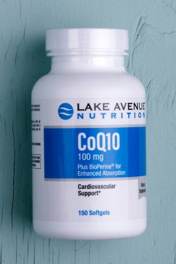 KIEV, UKRAINE - 18 Mayıs 2020: Mavi ahşap arka plana karşı bir şişe AVENUE Gölü KoQ10.