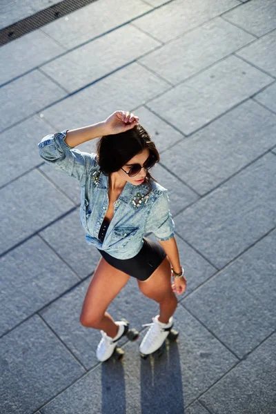 Mulher bonita em patins e um capacete rosa — Fotografia de Stock