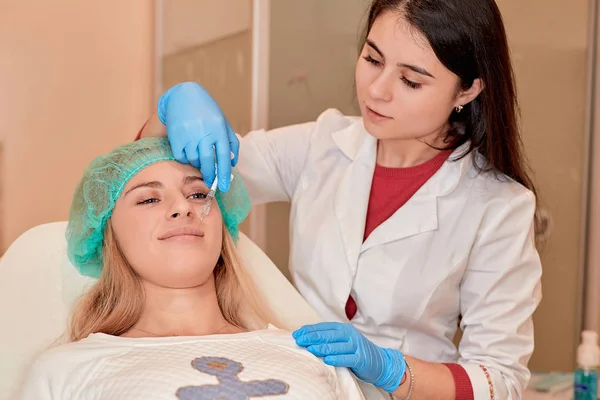 Nahaufnahme der schönen Frau bekommt Injektion in ihre Lippen. — Stockfoto