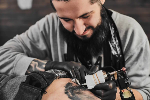 Tattoo master is tattooing in the tattoosalon — Stock Photo, Image