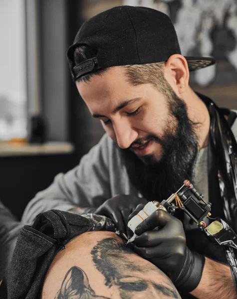 Mestre de tatuagem está tatuando no tatuador — Fotografia de Stock