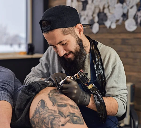 Tattoo master is tattooing in the tattoosalon — Stock Photo, Image