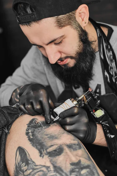 Le maître du tatouage tatoue dans le salon de tatouage — Photo