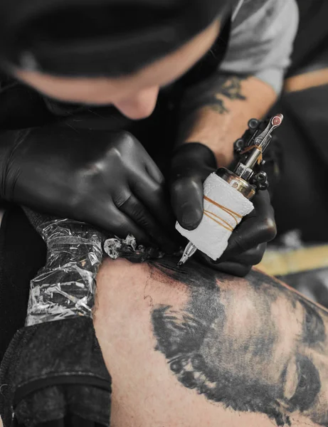 Tattoo master is tattooing in the tattoosalon — Stock Photo, Image