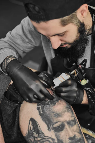 Tattoo master is tattooing in the tattoosalon — Stock Photo, Image