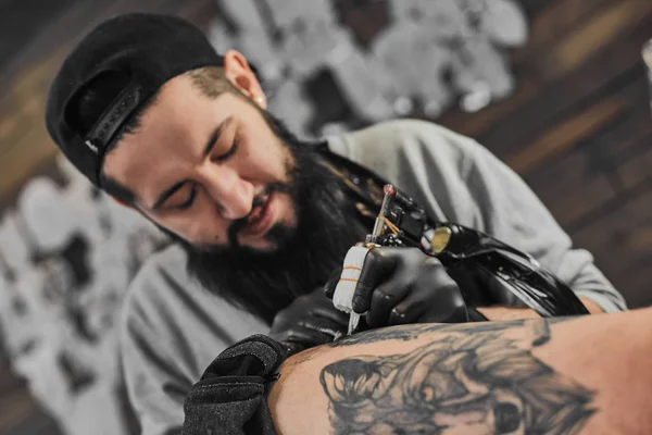 Mestre de tatuagem está tatuando no tatuador — Fotografia de Stock