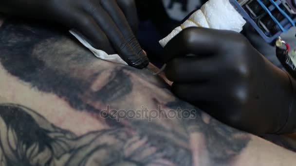 Maestro del tatuaje en guantes negros, tatuajes en la piel — Vídeos de Stock