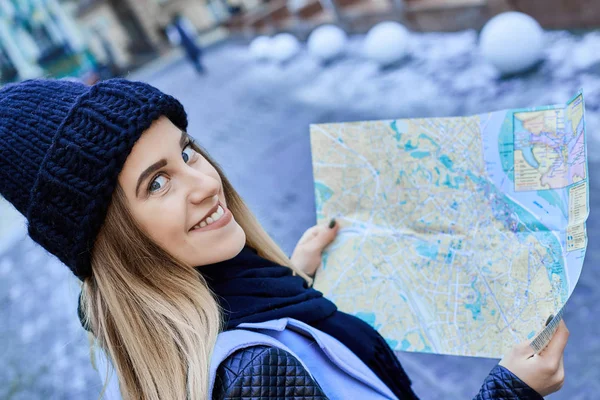 Hermosa chica mirando el mapa de manera correcta en una ciudad extranjera — Foto de Stock