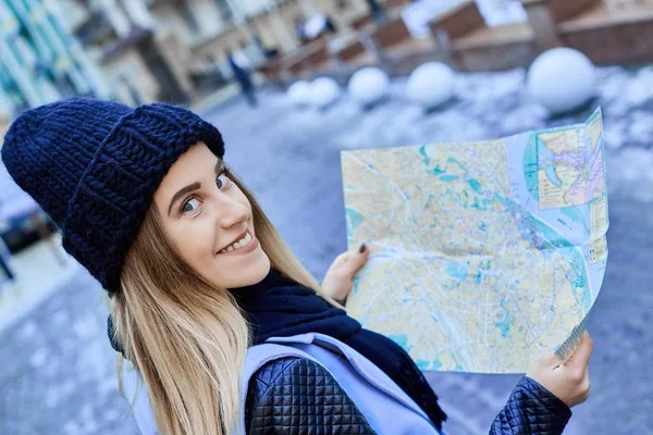 Hermosa chica mirando el mapa de manera correcta en una ciudad extranjera — Foto de Stock