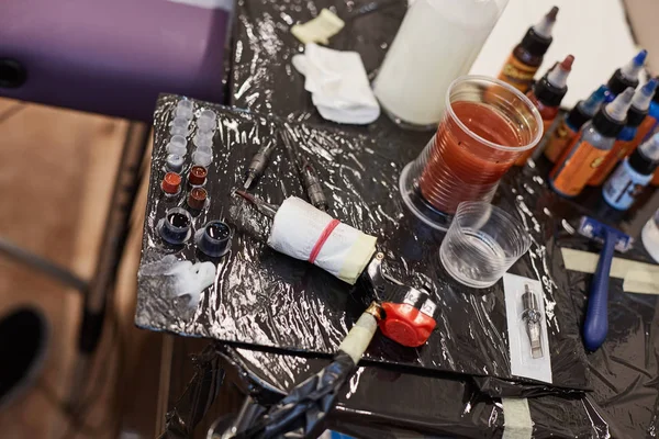 Dövme makinesi ve şişe renkli mürekkeplerle parçaları — Stok fotoğraf