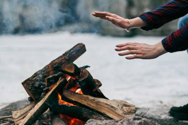 Kız ellerini yangın yanında kışın sıcak.
