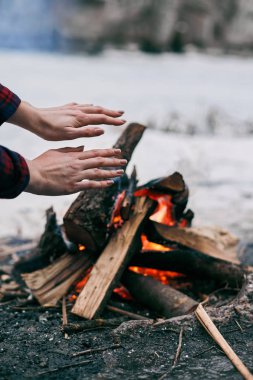 Kız ellerini yangın yanında kışın sıcak.