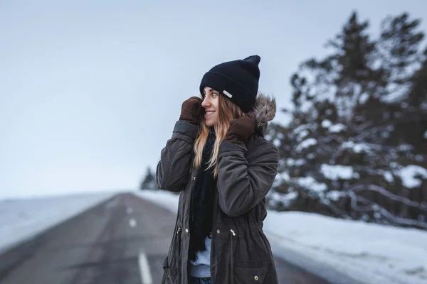 Menina está de pé na estrada de inverno — Fotografia de Stock