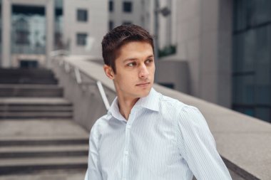 Açık havada kentsel duvara yaslanmış cool iş adamı