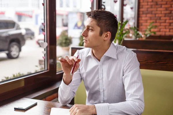 Joven gerente trabajando escribe en un cuaderno al aire libre — Foto de Stock