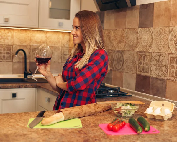 Hermosa chica en la cocina con una copa de vino — Foto de Stock