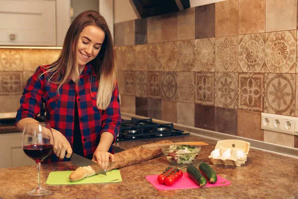 Retrato de una hermosa mujer joven cortando verduras en la cocina — Foto de Stock