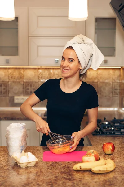 Hermosa joven sonriendo mientras hornea en la cocina — Foto de Stock