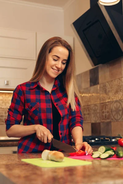 Vegetabiliska skärning, kvinna skär tomat med en kniv — Stockfoto