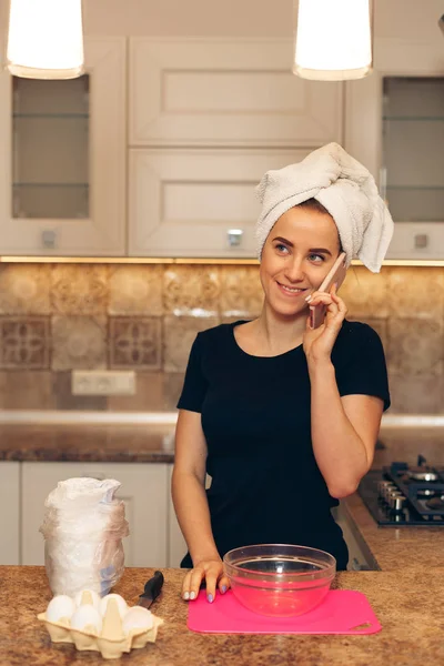 Agradable mujer alegre hablando por teléfono celular y cocinar — Foto de Stock