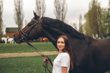 Güzel kız parkta bir at ile iletişim kurar