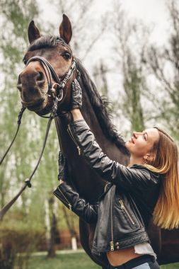 Güzel kız parkta bir at ile iletişim kurar