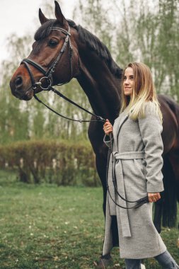 Güzel kız parkta bir at ile iletişim kurar